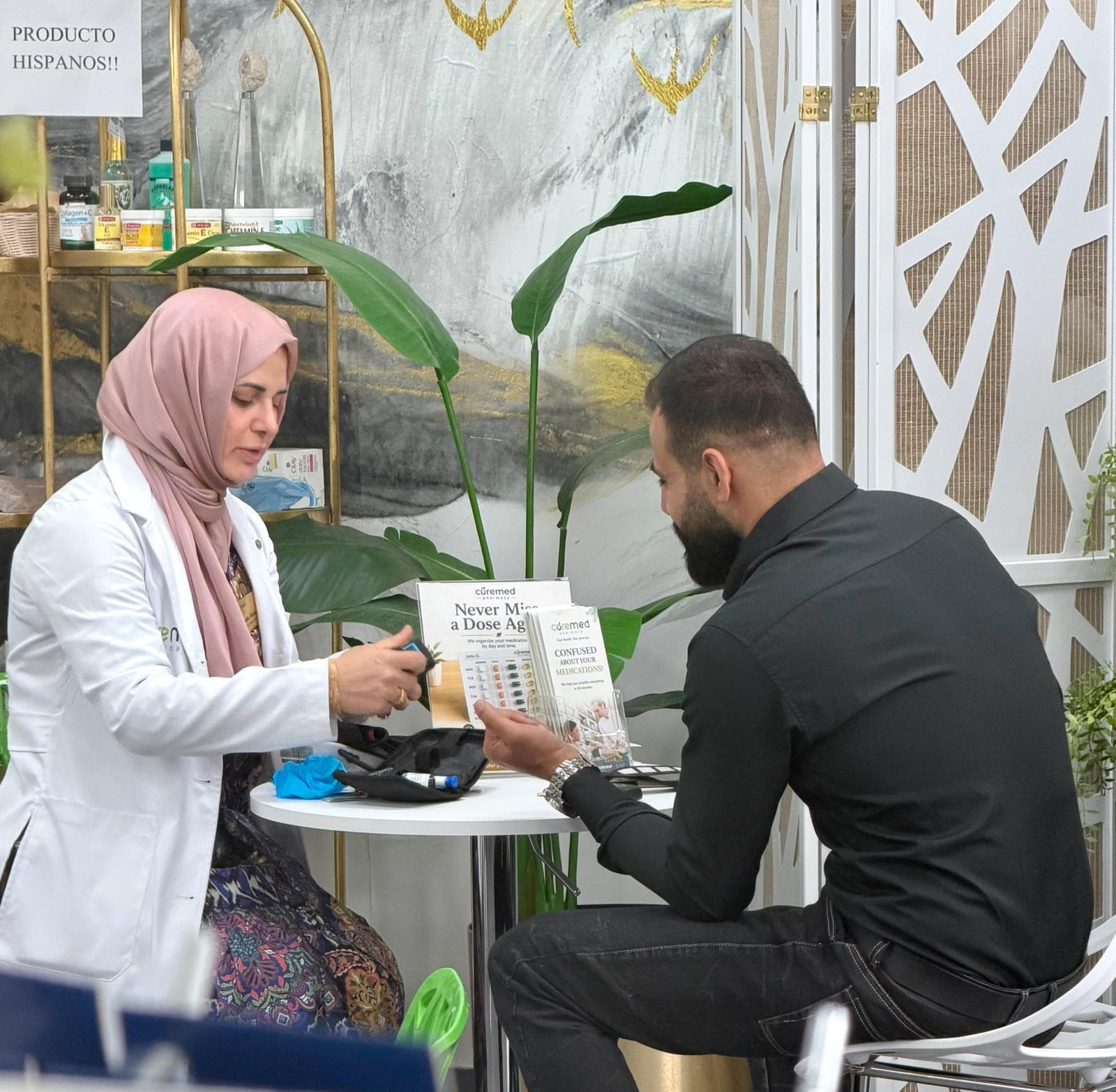 Dr. Ghada consulting with a patient over medication organization at CureMed Pharmacy